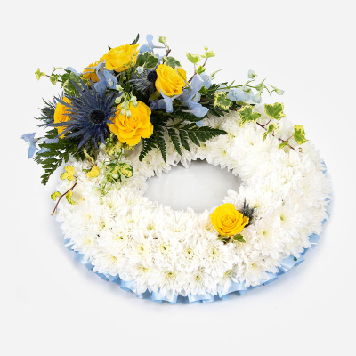Wreath SYM-319 - White Massed Wreath with Blue & Yellow Spray. 31cm / 12” Oasis Wreath Frame.